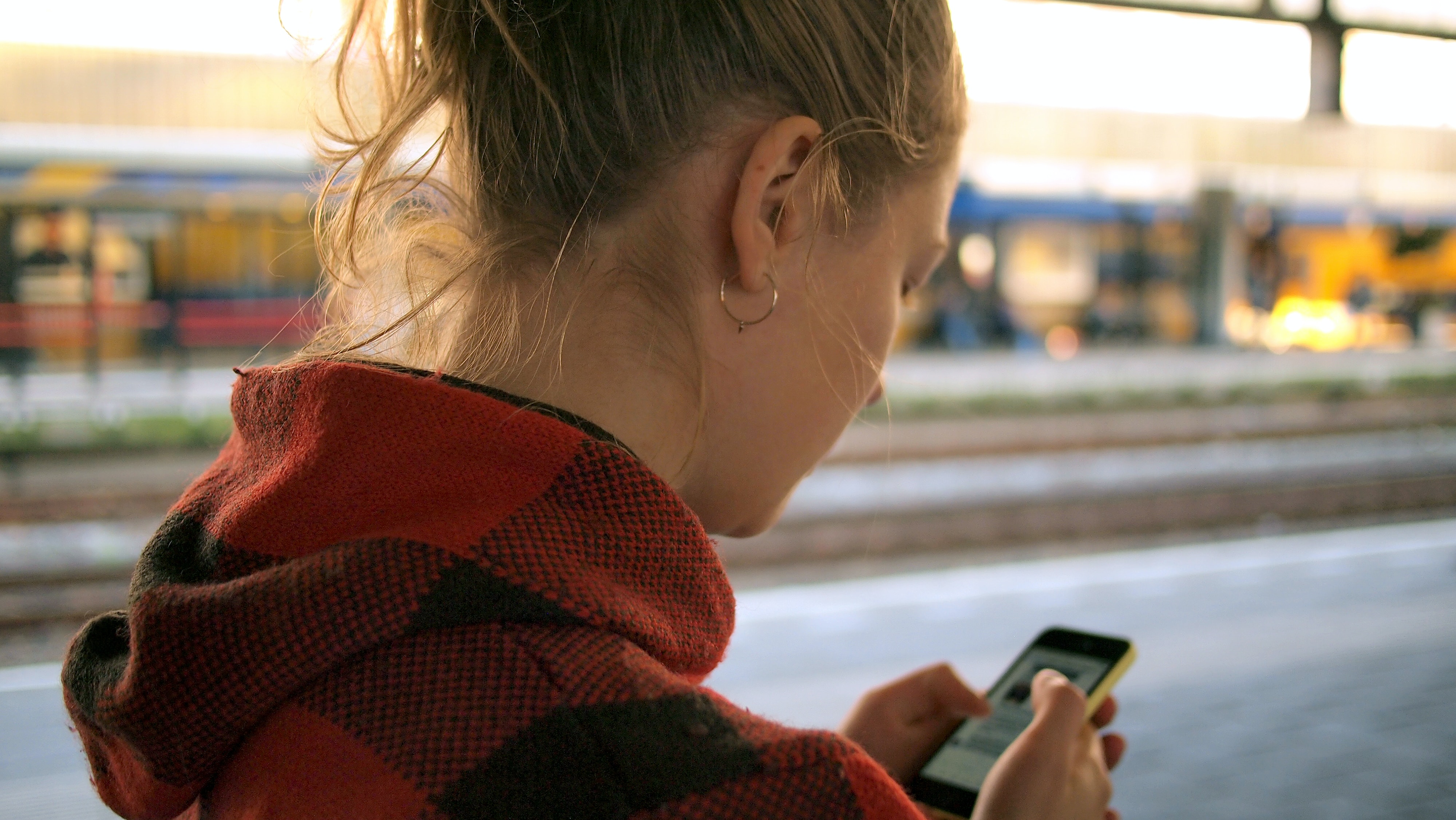 blonde woman on phone at train station