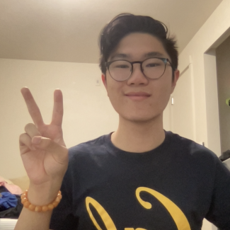 Victor Kuan putting up a peace sign and smiling 