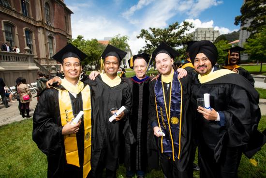 photo of four graduate students in graduation robes and Prof. Steve Weber in the center. 