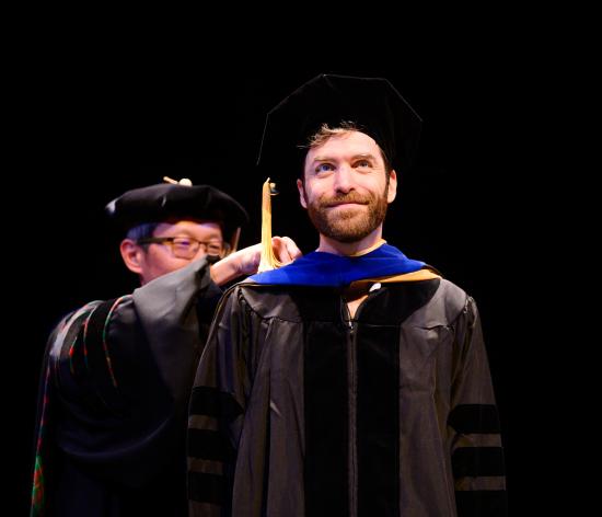 graduate being hooded by professor 