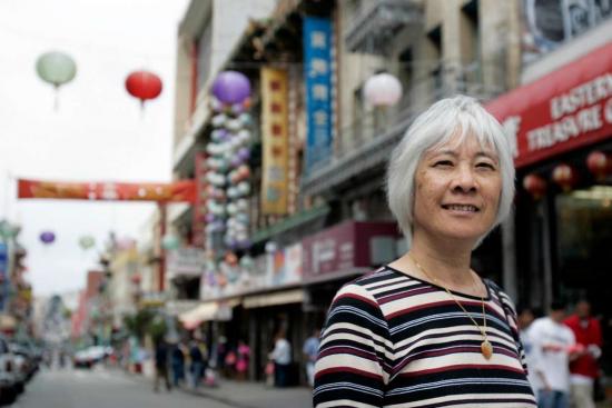 photo of Judy Yung standing in front of a street in San Francisco Chinatown