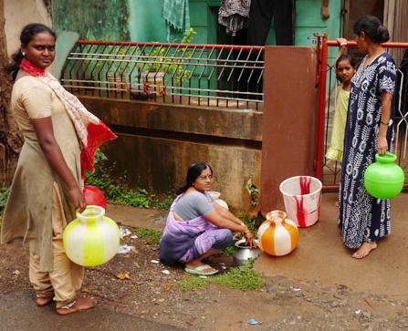 Women in Hubli, India, store water in pails because running water is not always available throughout the course of the day.