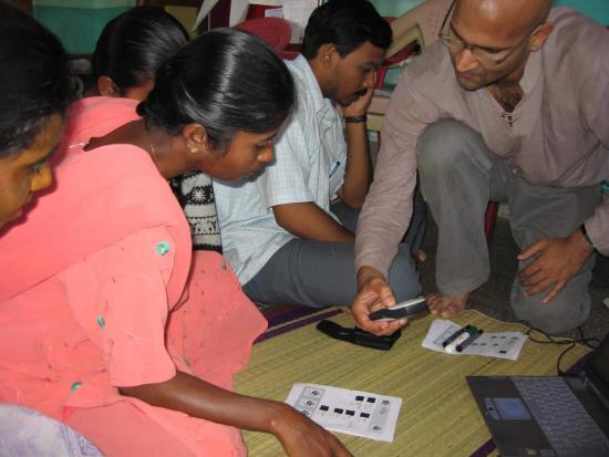 Tapan Parikh (right) helping users in India learn how to use the CAM mobile phone framework